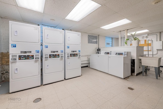 shared laundry area with a sink, light floors, washer and dryer, and stacked washer / dryer