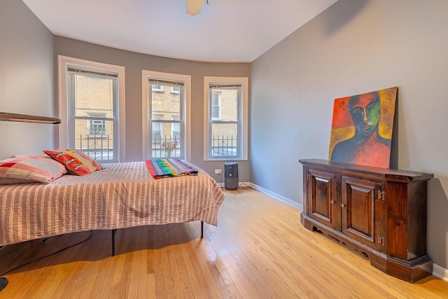 bedroom featuring light wood finished floors and baseboards