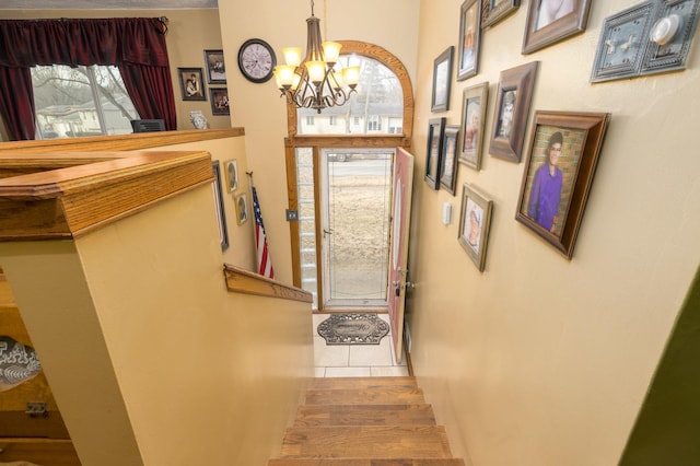 tiled entrance foyer featuring a wealth of natural light and a notable chandelier