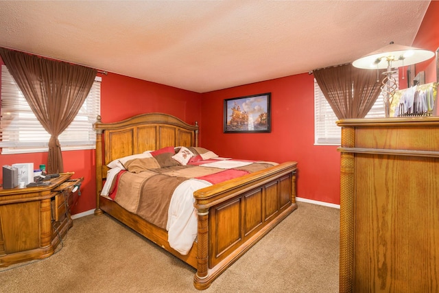 carpeted bedroom featuring a textured ceiling and baseboards