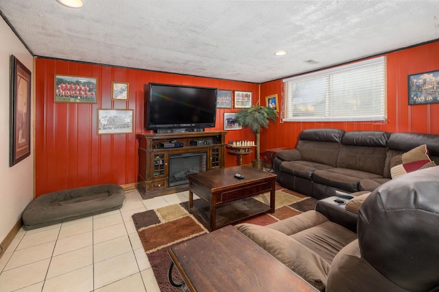 living area with a fireplace, baseboards, a textured ceiling, and tile patterned floors