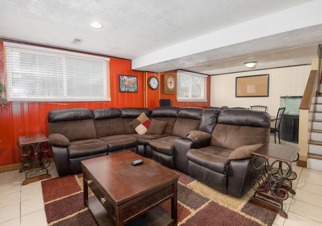 living room featuring visible vents, stairway, a textured ceiling, and tile patterned floors