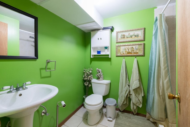 full bath with toilet, a sink, a shower with curtain, baseboards, and tile patterned floors