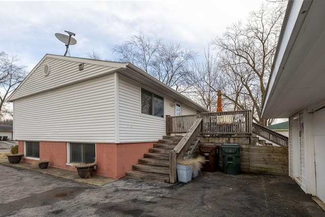 view of side of property with stairway and a wooden deck