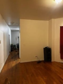 empty room featuring dark wood finished floors and baseboards