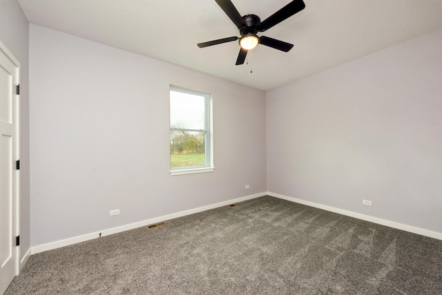 carpeted spare room with visible vents, ceiling fan, and baseboards