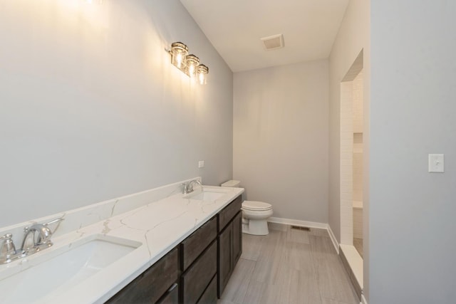 full bathroom with toilet, a shower, a sink, and visible vents