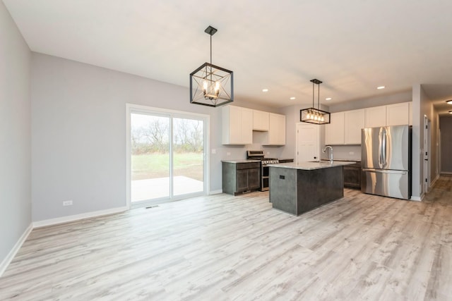 kitchen featuring light wood finished floors, baseboards, appliances with stainless steel finishes, a sink, and recessed lighting