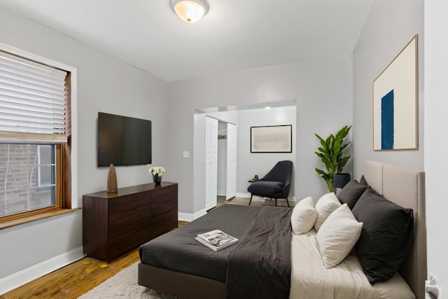 bedroom featuring light wood-style floors and baseboards