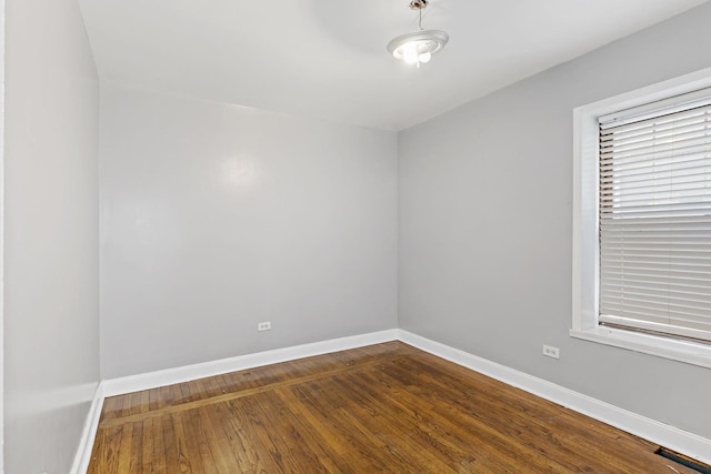 empty room with visible vents, baseboards, and wood finished floors