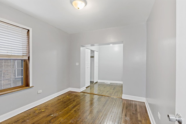 empty room featuring baseboards and wood finished floors