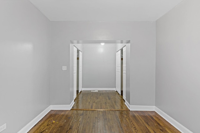 hall with baseboards and dark wood finished floors