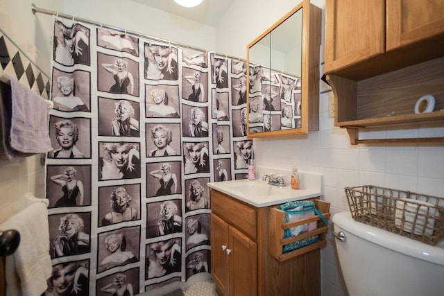 bathroom with decorative backsplash, toilet, a shower with curtain, vanity, and tile walls