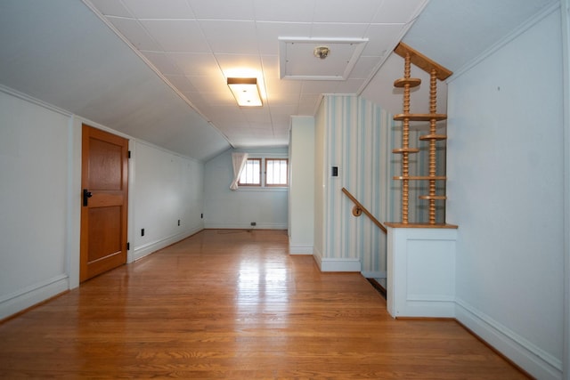 bonus room featuring baseboards, lofted ceiling, and light wood-style floors