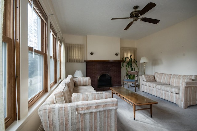 living area featuring carpet floors, a brick fireplace, and a ceiling fan