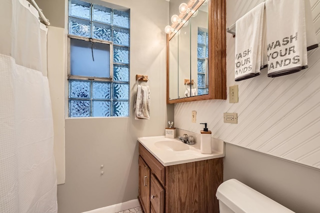 full bath featuring toilet, a wealth of natural light, vanity, and baseboards