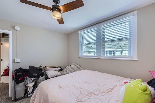 carpeted bedroom featuring ceiling fan and visible vents