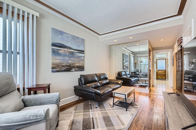 living room featuring hardwood / wood-style flooring, baseboards, and ornamental molding