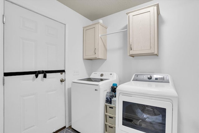 clothes washing area featuring washer and clothes dryer and cabinet space