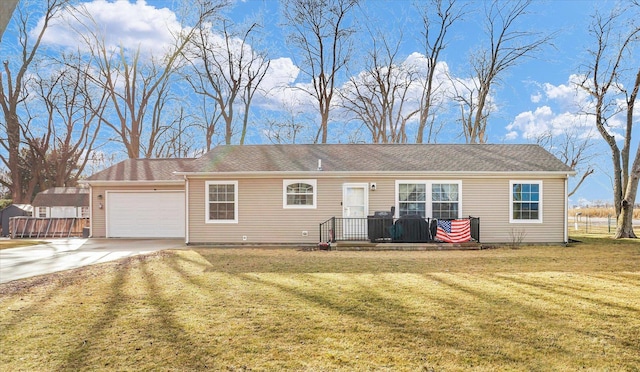 ranch-style home featuring a front lawn, concrete driveway, a deck, and an attached garage