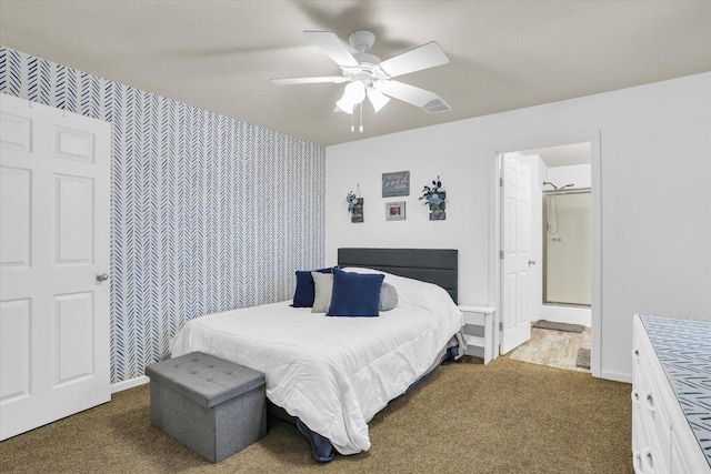 bedroom featuring an accent wall, visible vents, baseboards, and wallpapered walls