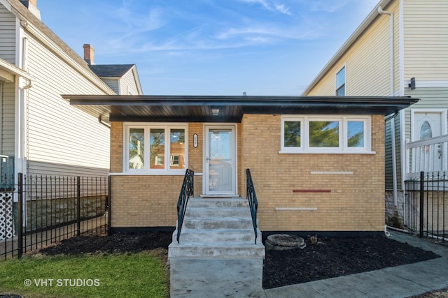 property entrance with brick siding and fence