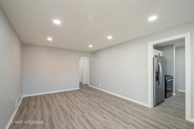 spare room with light wood-type flooring, baseboards, and recessed lighting