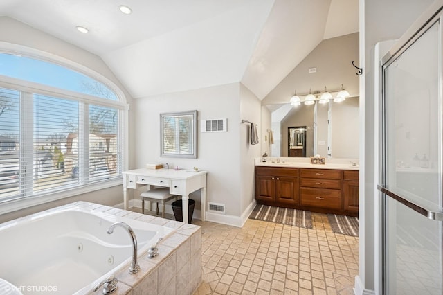 full bath with lofted ceiling, baseboards, visible vents, and a tub with jets