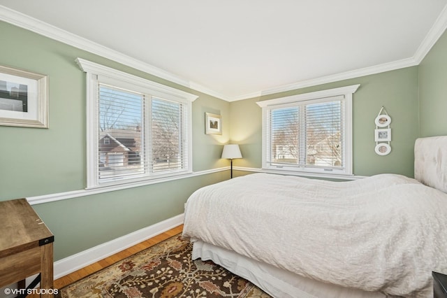 bedroom with baseboards, ornamental molding, and wood finished floors