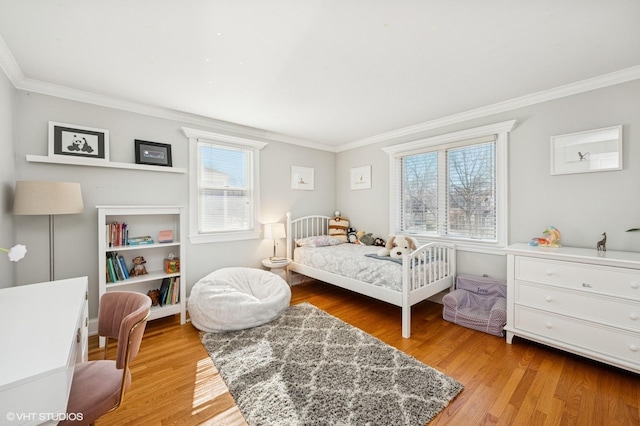 bedroom with light wood finished floors and ornamental molding