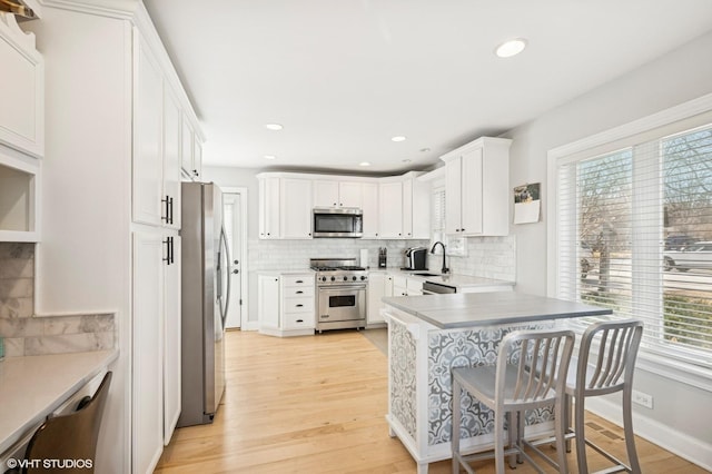 kitchen featuring a peninsula, light wood-style floors, plenty of natural light, and stainless steel appliances