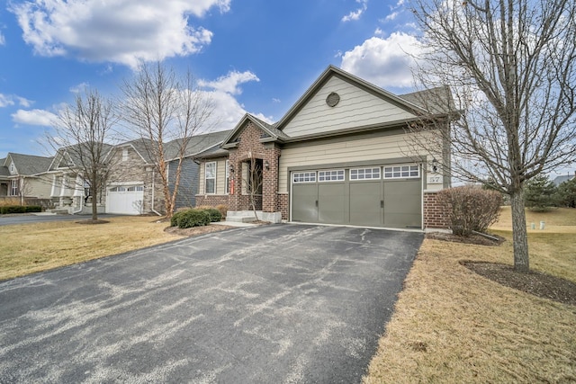 view of front of home featuring brick siding, an attached garage, and aphalt driveway