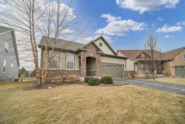 view of front facade featuring a garage, driveway, brick siding, and a front lawn