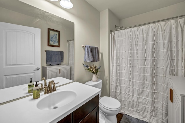 bathroom featuring toilet, a shower with shower curtain, and vanity