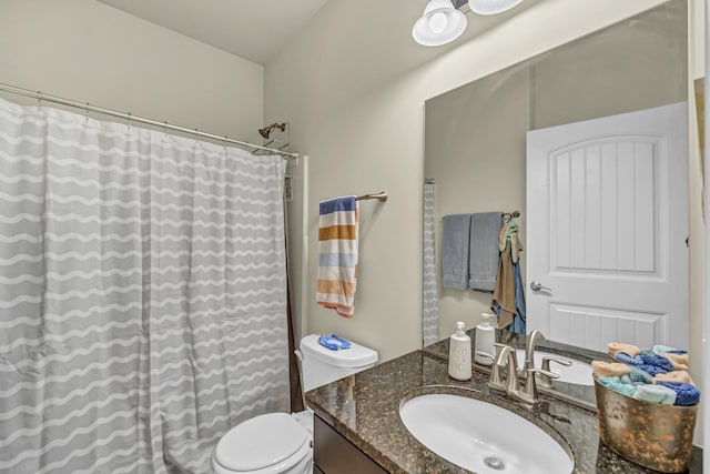 bathroom featuring a shower with shower curtain, vanity, and toilet