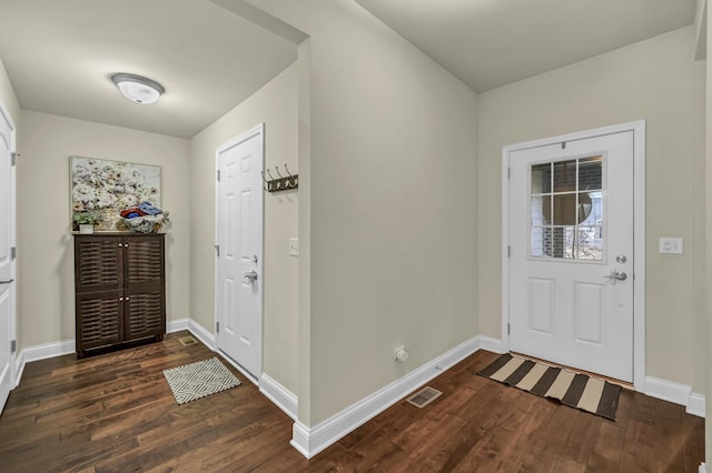 foyer entrance featuring dark wood-style floors, visible vents, and baseboards