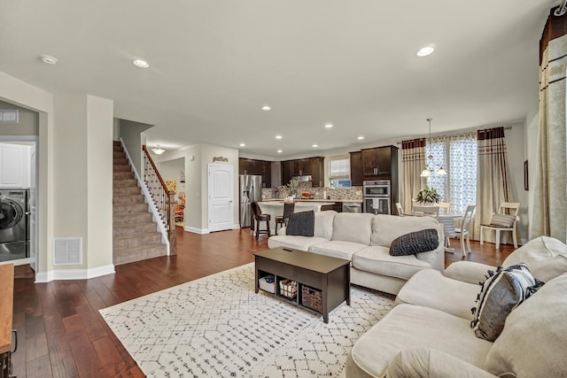 living room with dark wood-style floors, recessed lighting, visible vents, baseboards, and stairs