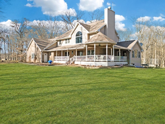 exterior space with a porch, a lawn, a chimney, and a ceiling fan