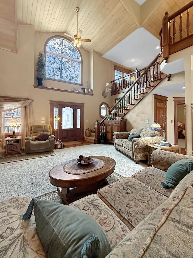 living area with high vaulted ceiling, wooden ceiling, carpet flooring, a ceiling fan, and stairs