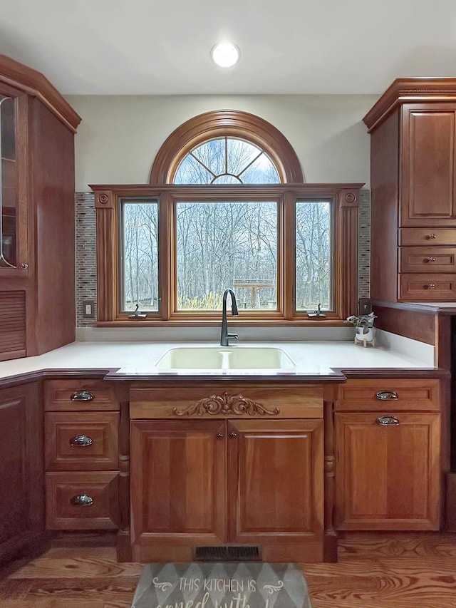 kitchen featuring light countertops, a sink, and brown cabinets