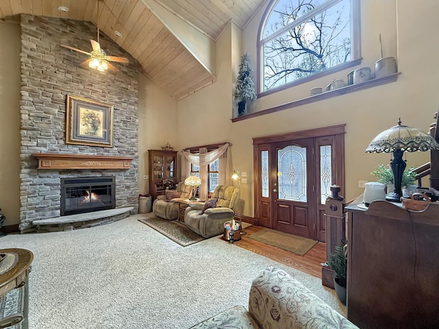 entrance foyer with wooden ceiling, baseboards, high vaulted ceiling, and a stone fireplace