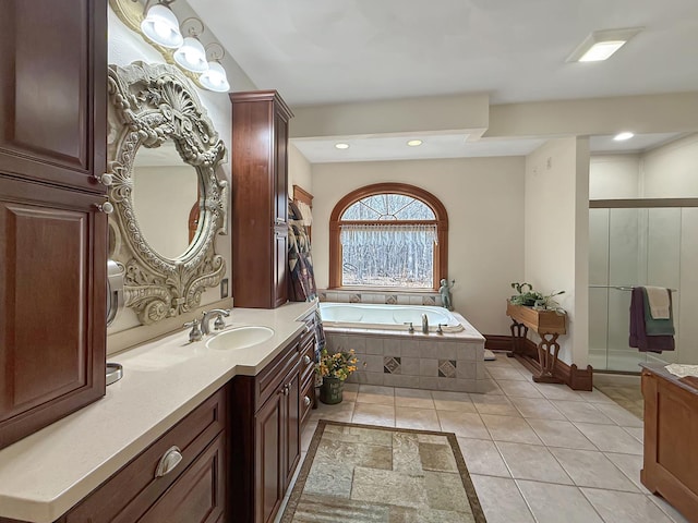 bathroom featuring tile patterned flooring, vanity, a shower stall, and a bath