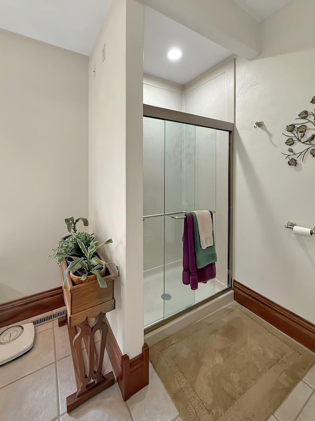 bathroom with tile patterned flooring, a shower stall, and baseboards