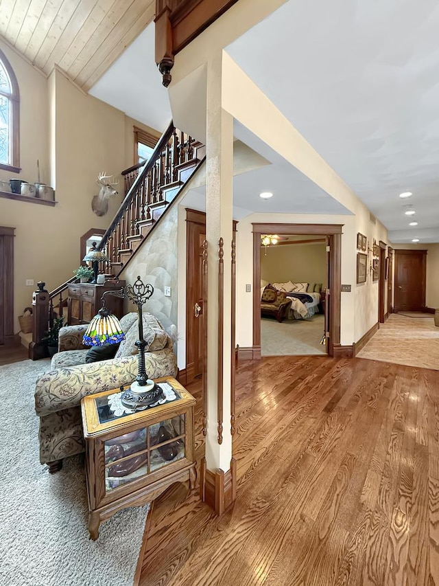 interior space with recessed lighting, vaulted ceiling, wood finished floors, baseboards, and stairs