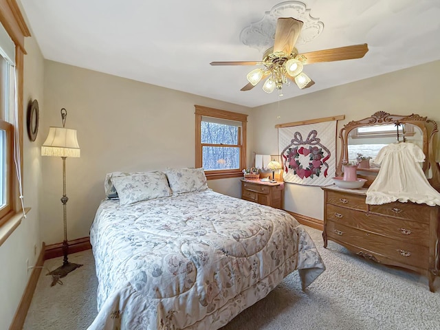 bedroom with baseboards, ceiling fan, and light colored carpet