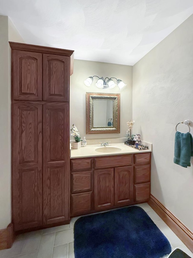 bathroom with baseboards, vanity, and tile patterned floors