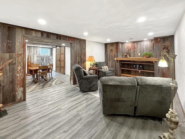 living room with wood walls, wood finished floors, and recessed lighting