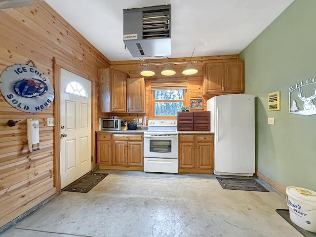 kitchen with light countertops, a heating unit, wood walls, unfinished concrete floors, and white appliances