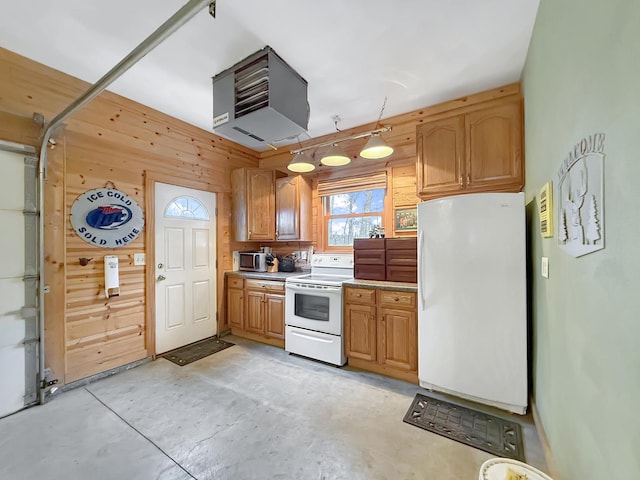 kitchen featuring white appliances, wooden walls, light countertops, and concrete flooring