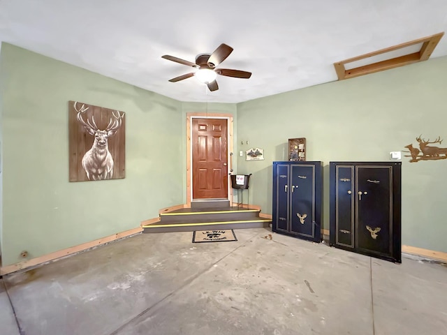 foyer with ceiling fan, unfinished concrete flooring, and baseboards